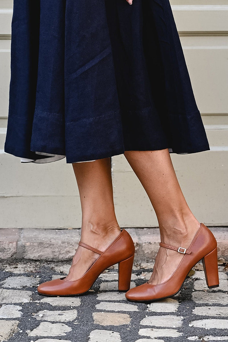 Classic brown buckle sandal on a plain background.
