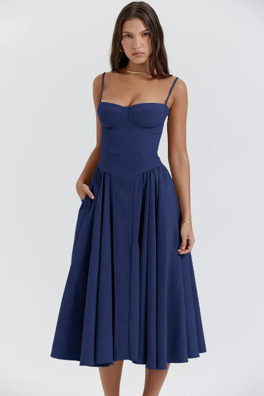 Woman standing in a lightweight summer midi dress against a plain background.