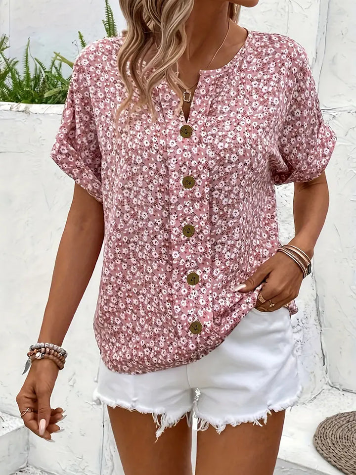  Female model in a floral printed blouse with long sleeves and a flowing silhouette.