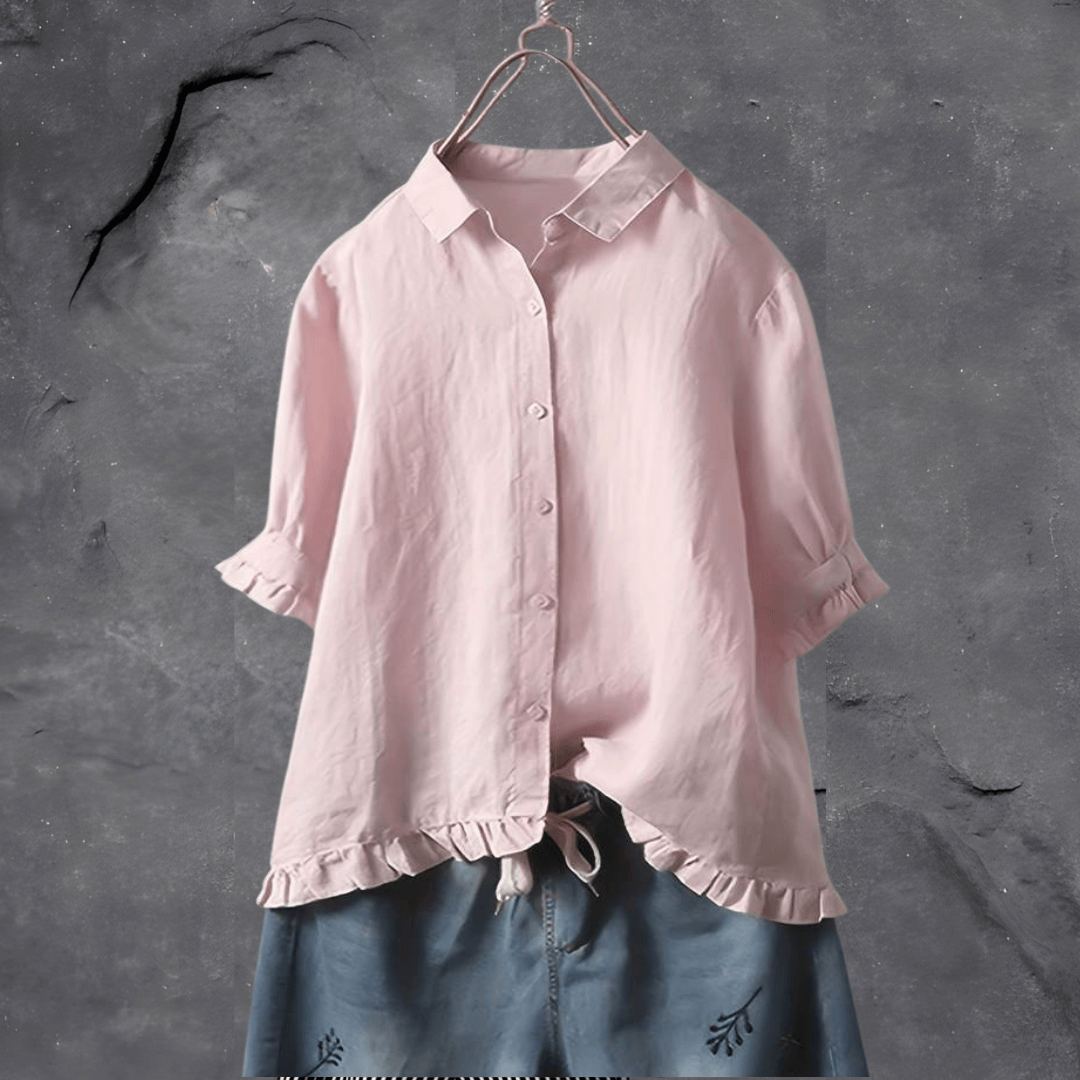  Woman in a relaxed-fit blouse styled for everyday wear on a plain background.