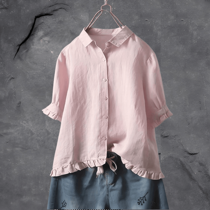  Woman in a relaxed-fit blouse styled for everyday wear on a plain background.