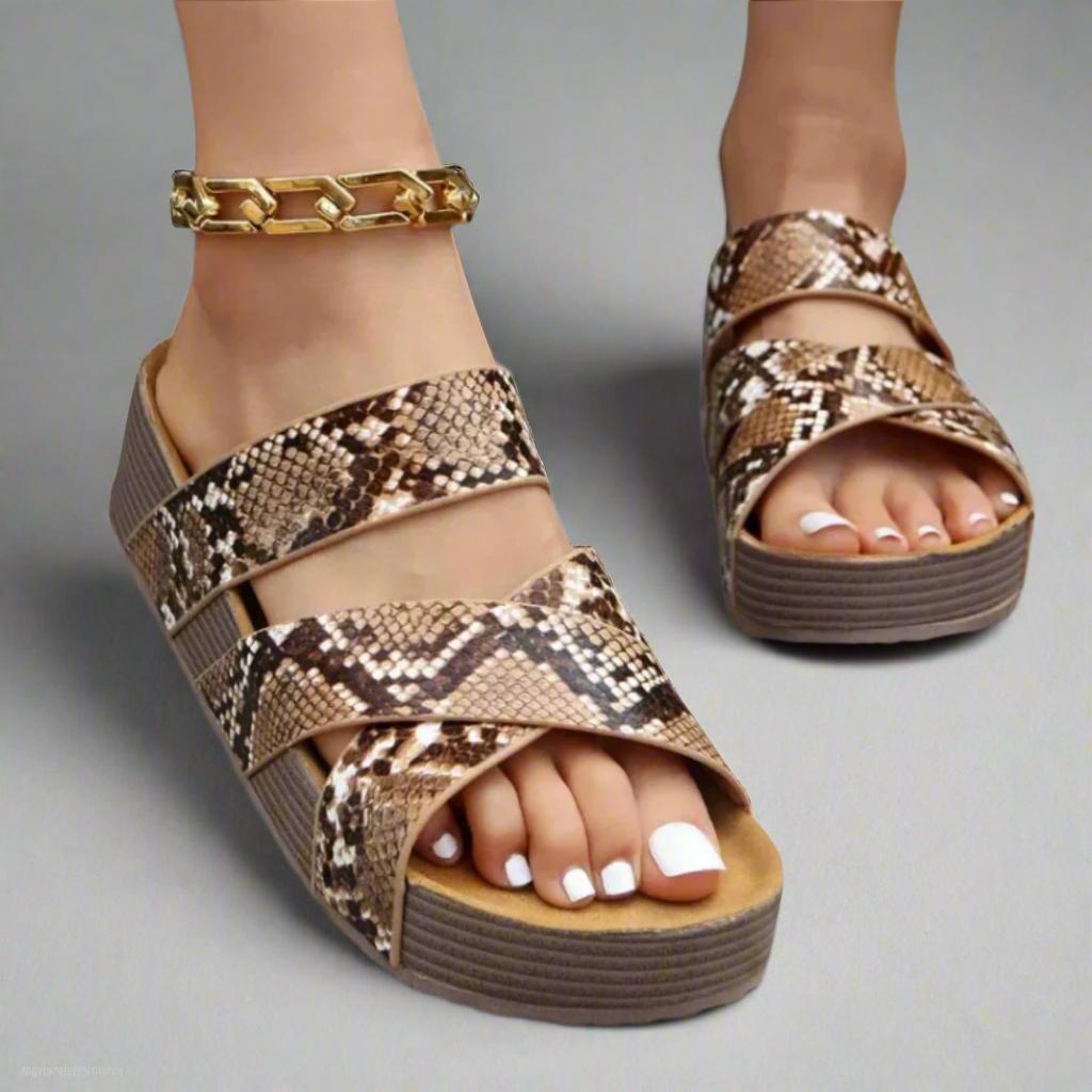 Female wearing open-toe sandals with cushioned foot support on a plain background.