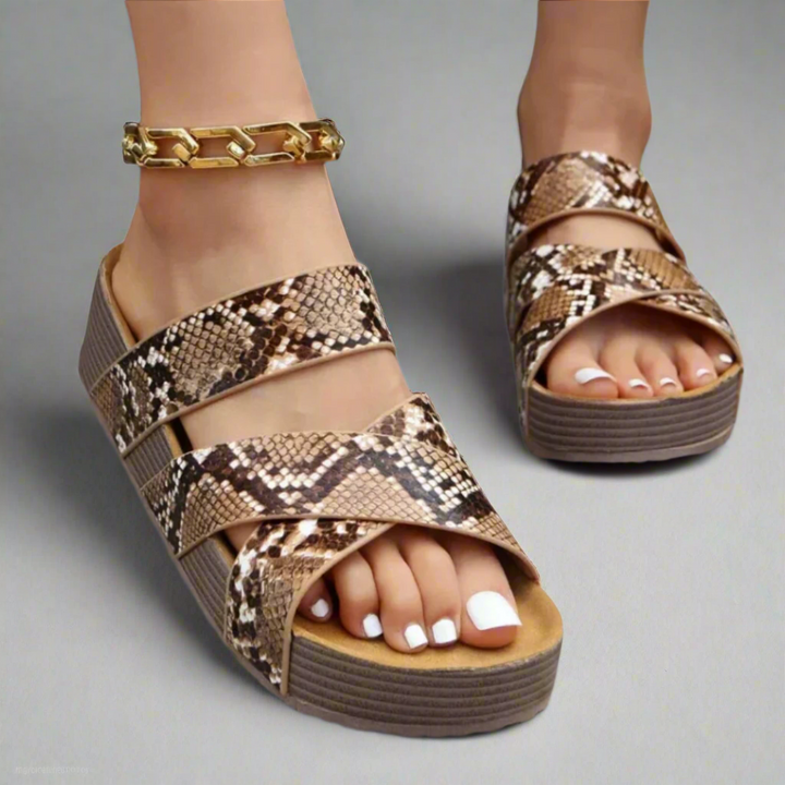 Female wearing open-toe sandals with cushioned foot support on a plain background.