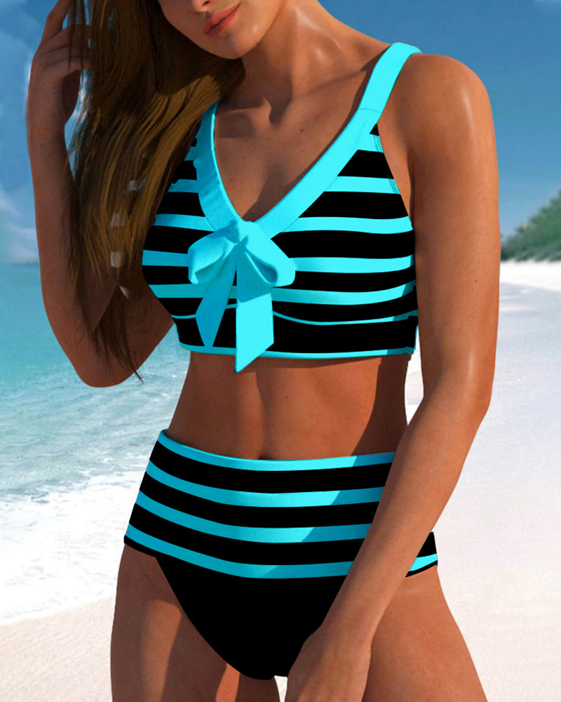 Female model in a boho style tankini swimsuit with full coverage bottoms on a plain background.