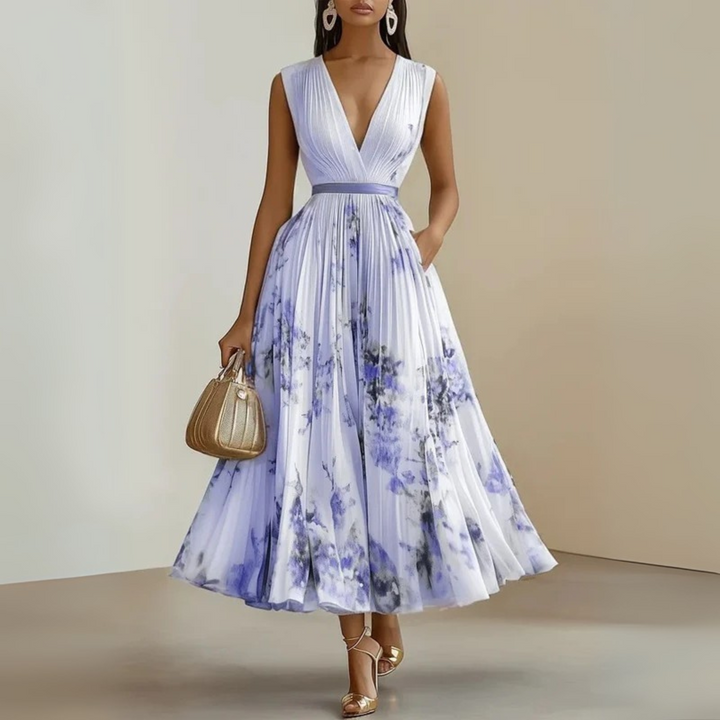 Female in a V-neck maxi dress with vertical pleats throughout the skirt.