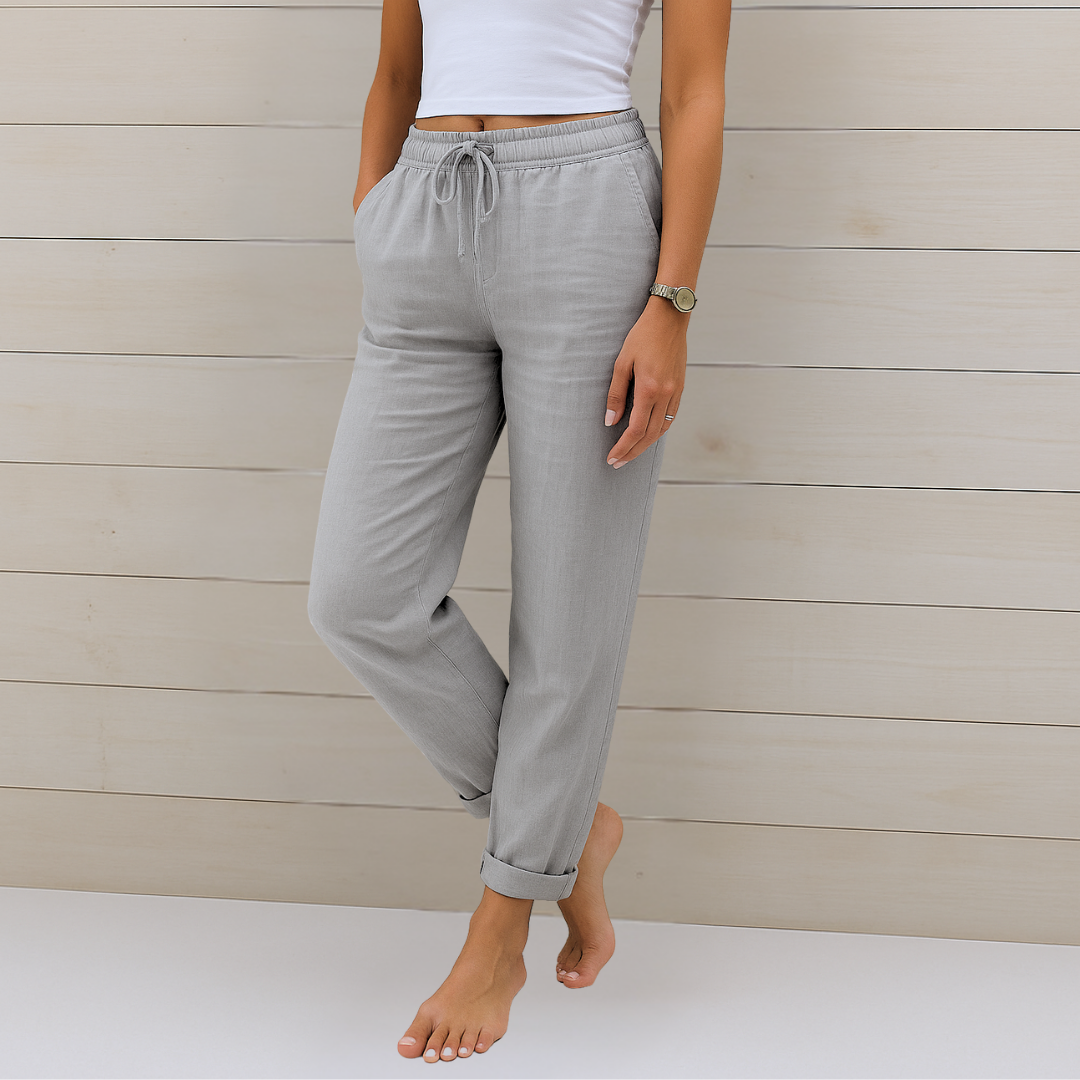 Woman wearing versatile elastic waist trousers styled against a plain backdrop.