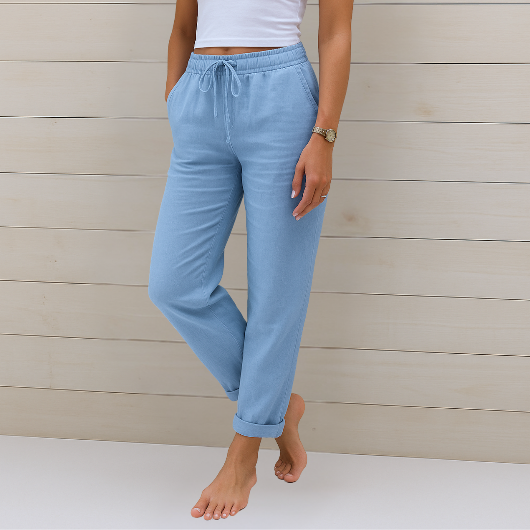 Woman showcasing relaxed fit trousers with a comfortable stretch waistband on a plain background.
