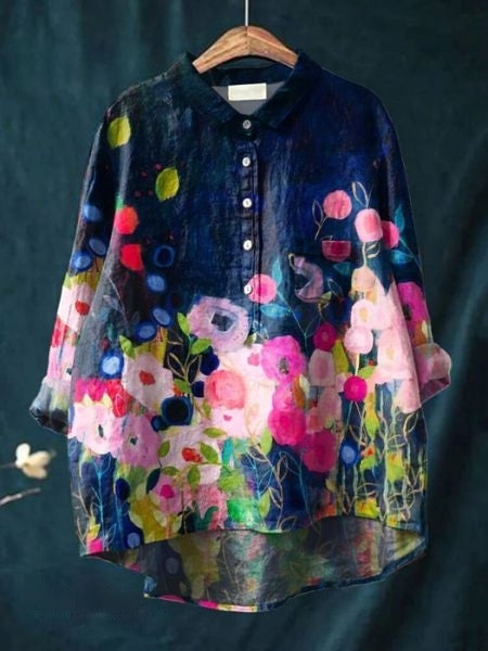  Woman modelling a printed blouse with a soft flowing shape against a plain background.