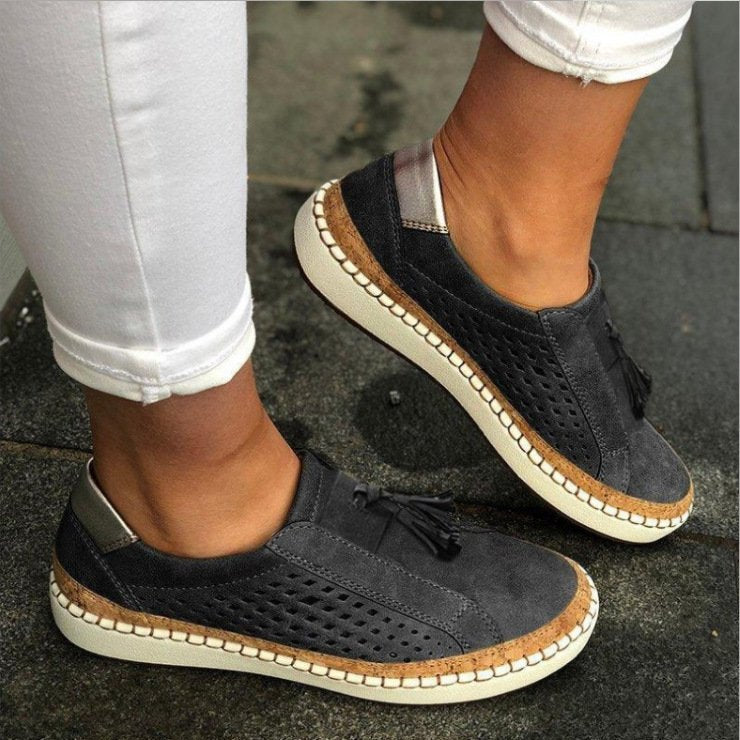 Female wearing lightweight slip-on slippers on a plain background.