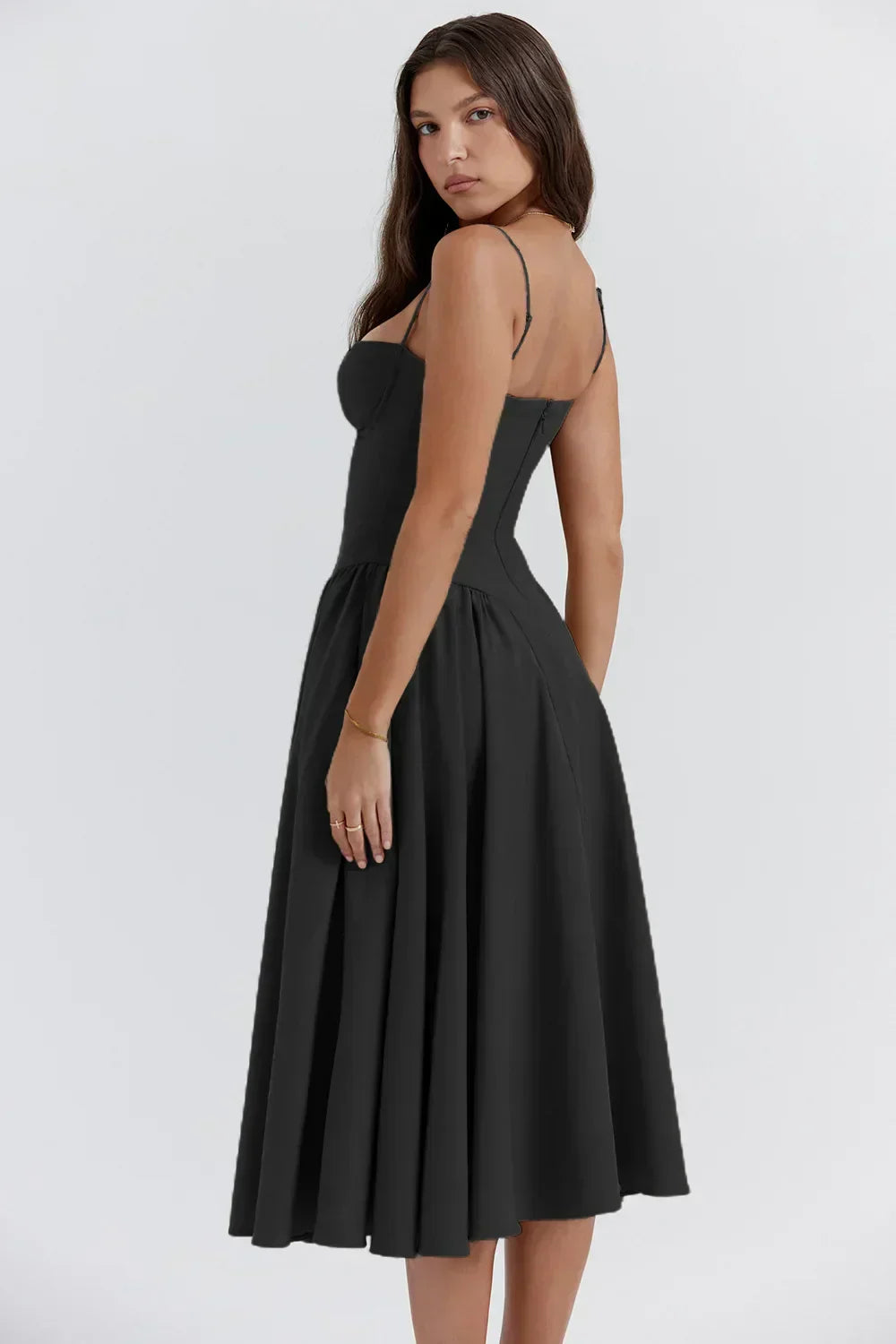 Model in a soft draping midi dress with slim shoulder straps on a plain background.