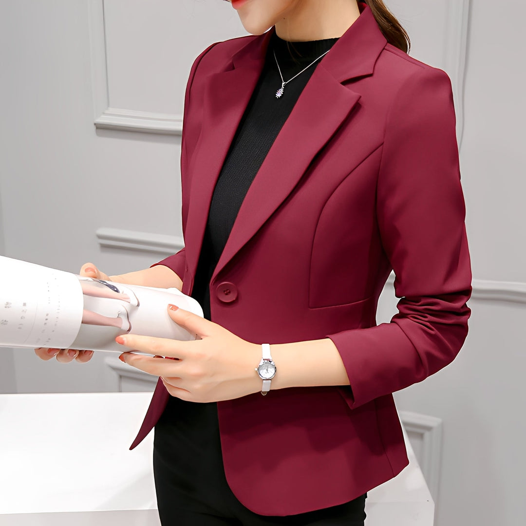  Female model in a structured blazer with a classic lapel design and tailored silhouette.