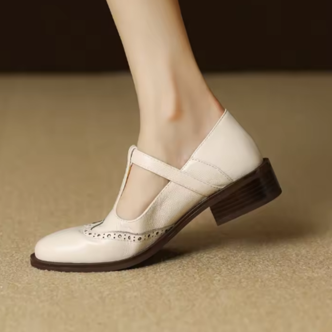 Brogue Mary Jane shoe with structured strap and rounded toe on a plain background.