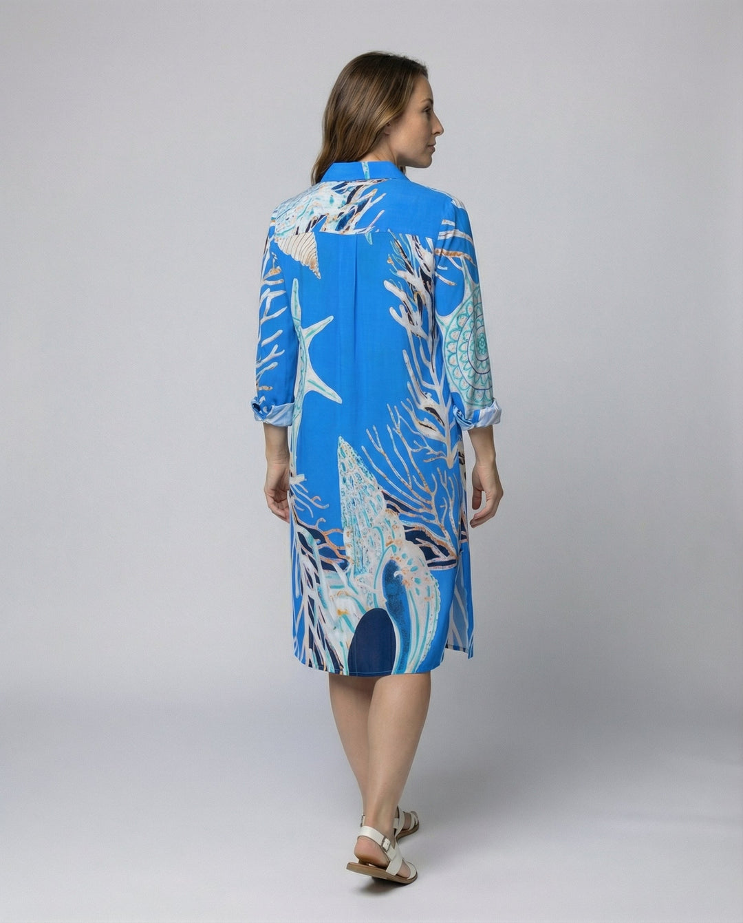 Female wearing a relaxed beach blouse with half sleeves and button front.
