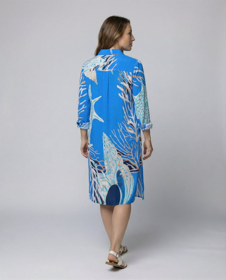Female wearing a relaxed beach blouse with half sleeves and button front.