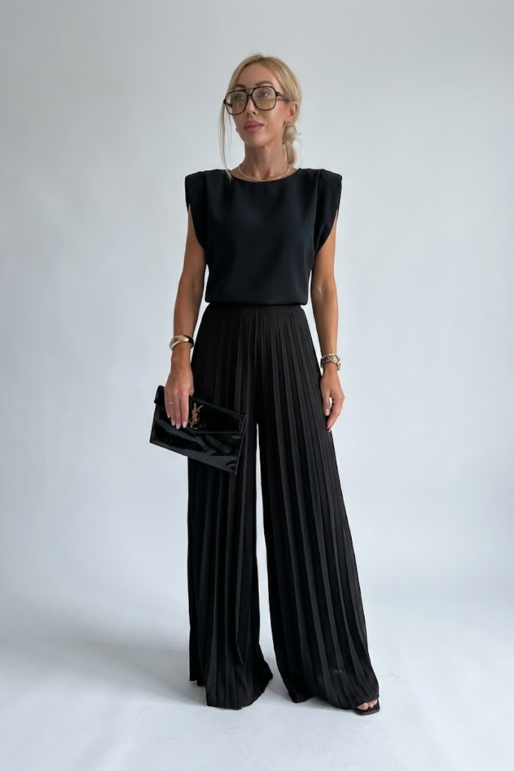 Female model wearing a sleeveless two-piece outfit with wide-leg trousers against a plain background.