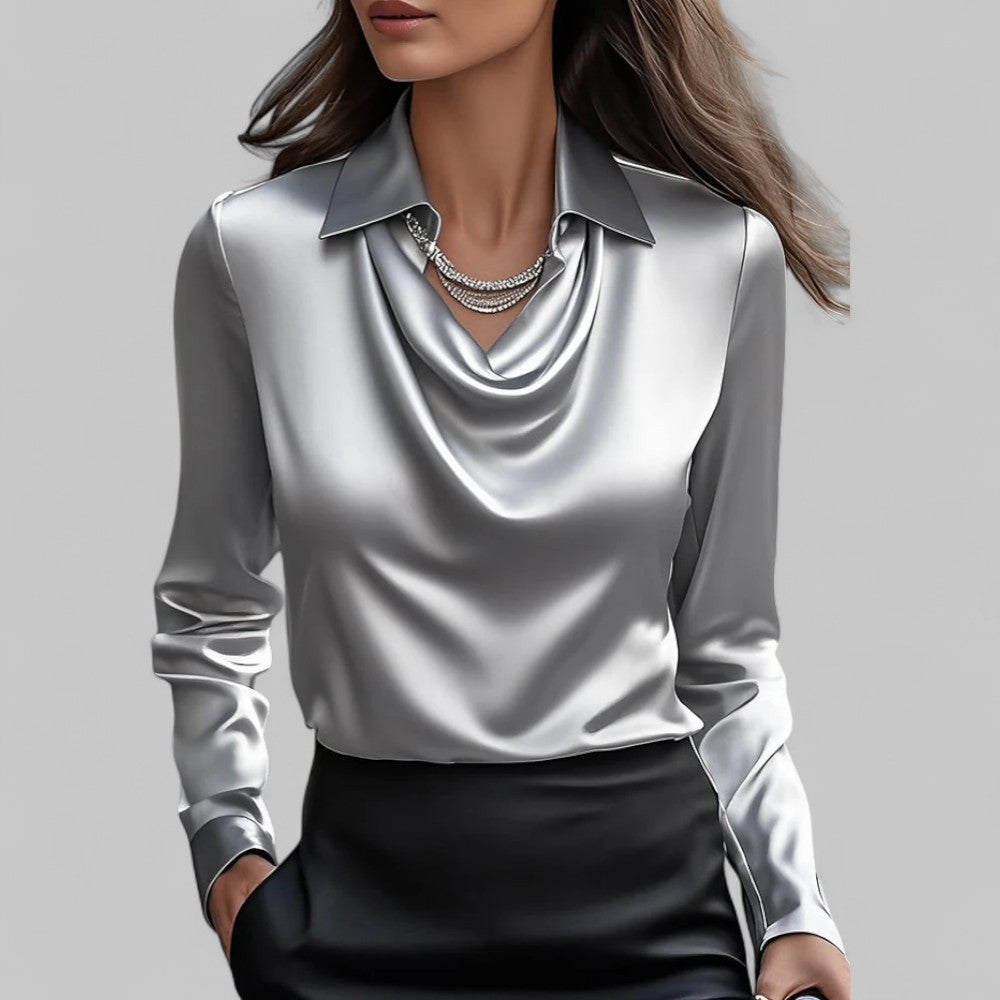 Woman in an elegant satin blouse featuring long sleeves and a flowing neckline on a plain background.