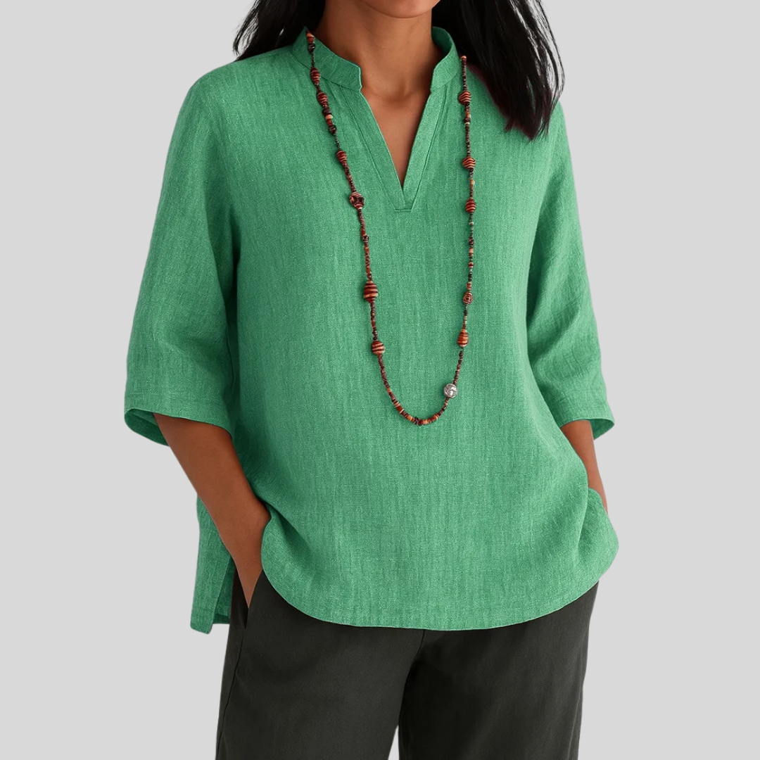 Female wearing a relaxed fit green blouse against a plain background.
