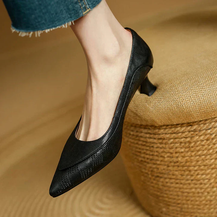 Female model in sleek kitten heel pumps on a plain background.
