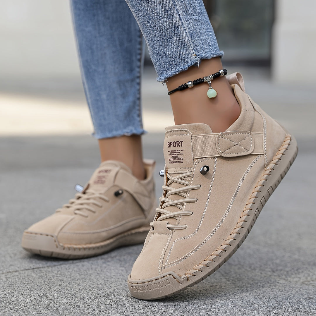  Woman showcasing casual lace trainers designed for everyday wear on a plain background.e 