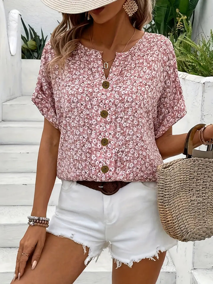 Female model wearing a floral long sleeve blouse with button-front detail against a plain background.