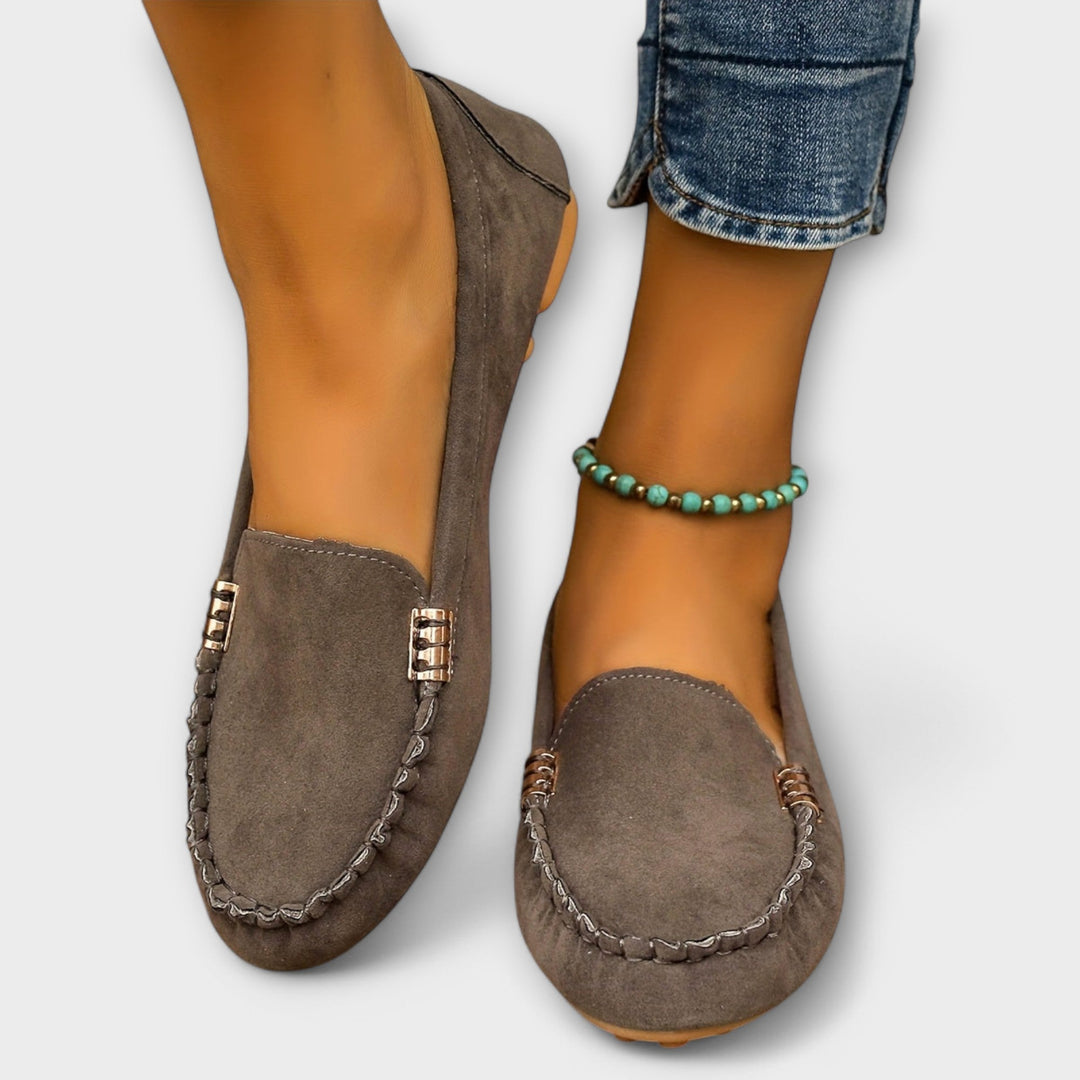 Female model wearing cushioned slip-on flats against a plain background.