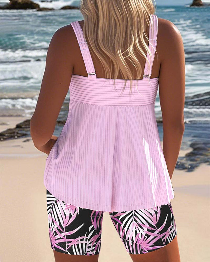 Female model in a printed swim top and high-waist bottom on a plain background.