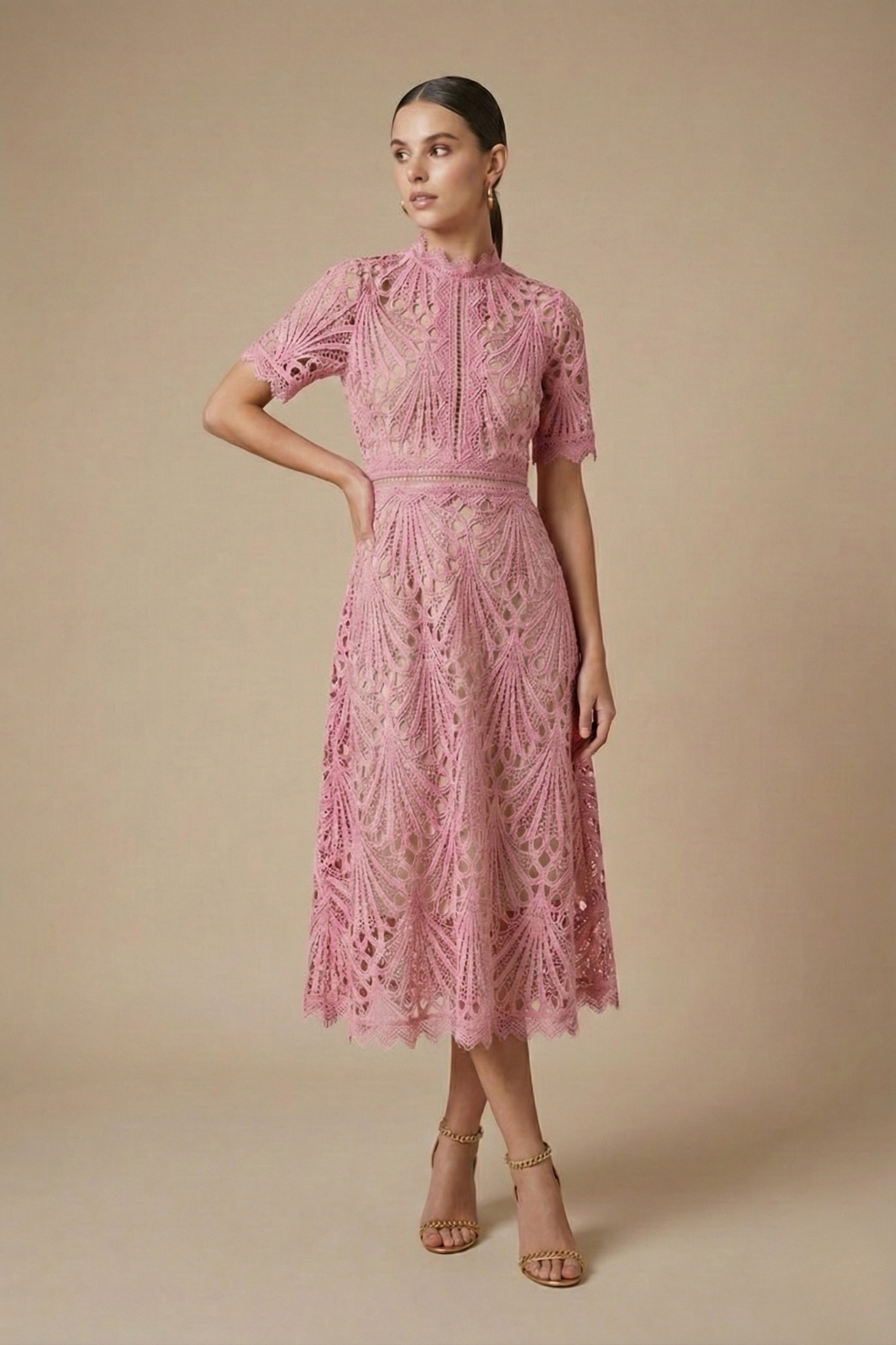 Woman posing in a geometric lace midi dress with frill collar against a plain background.