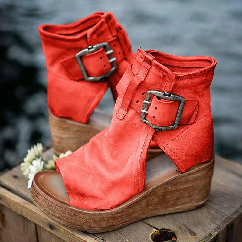 Woman modeling open toe wedge sandals against a plain background.