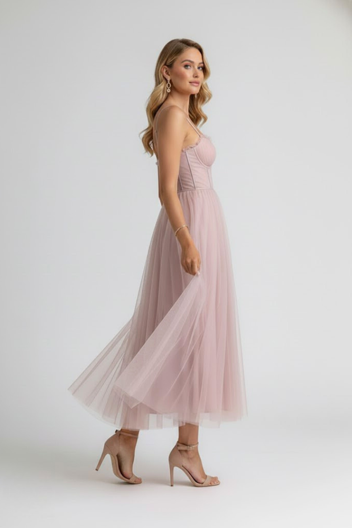 Female in a summer halter midi dress on a plain background.