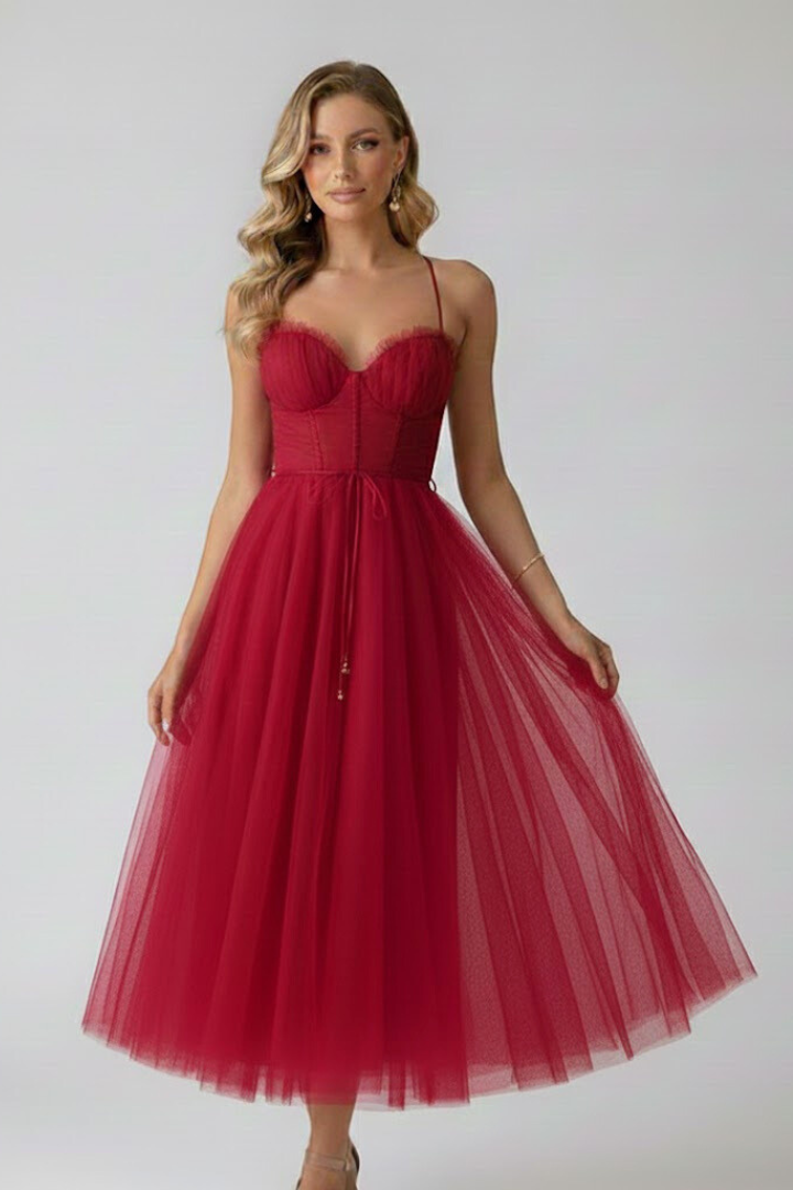 Female in a halter neckline dress for summer events on a plain background.