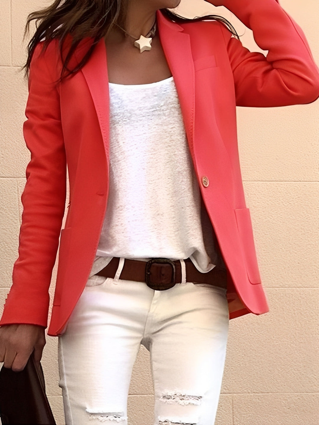 Female model wearing a slim fit tailored blazer on a plain background.