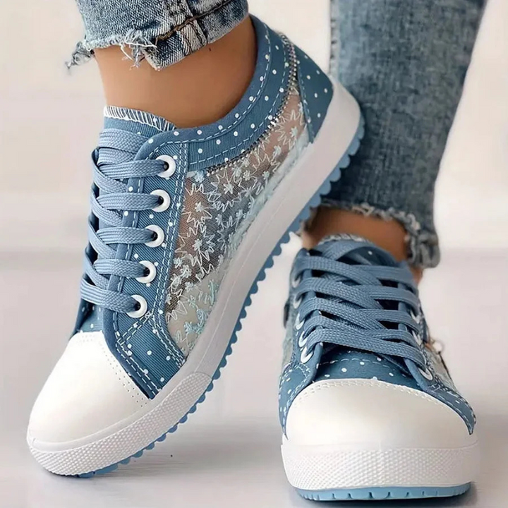  Woman showcasing casual lace-up trainers with a timeless silhouette on a plain background.