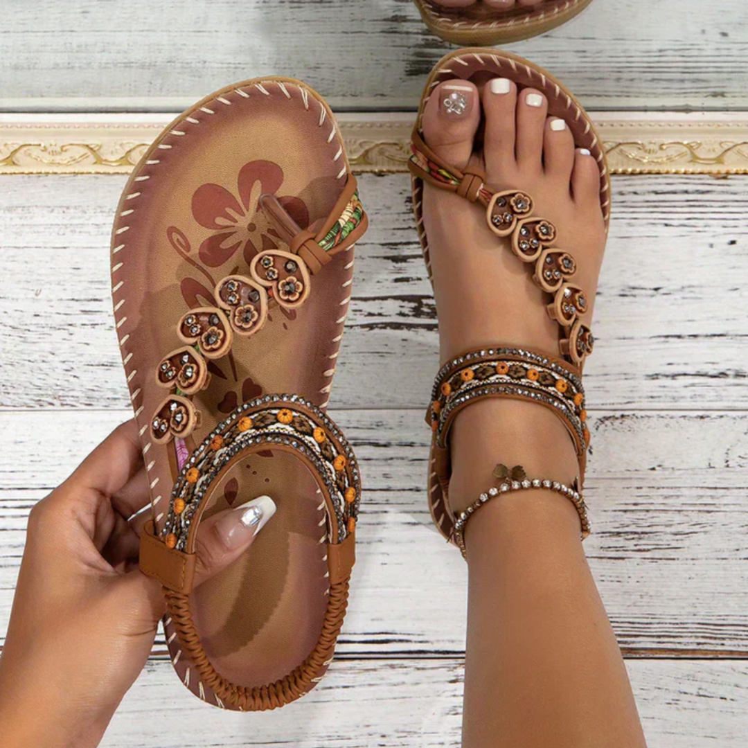 Woman wearing boho beach sandals against a plain background.