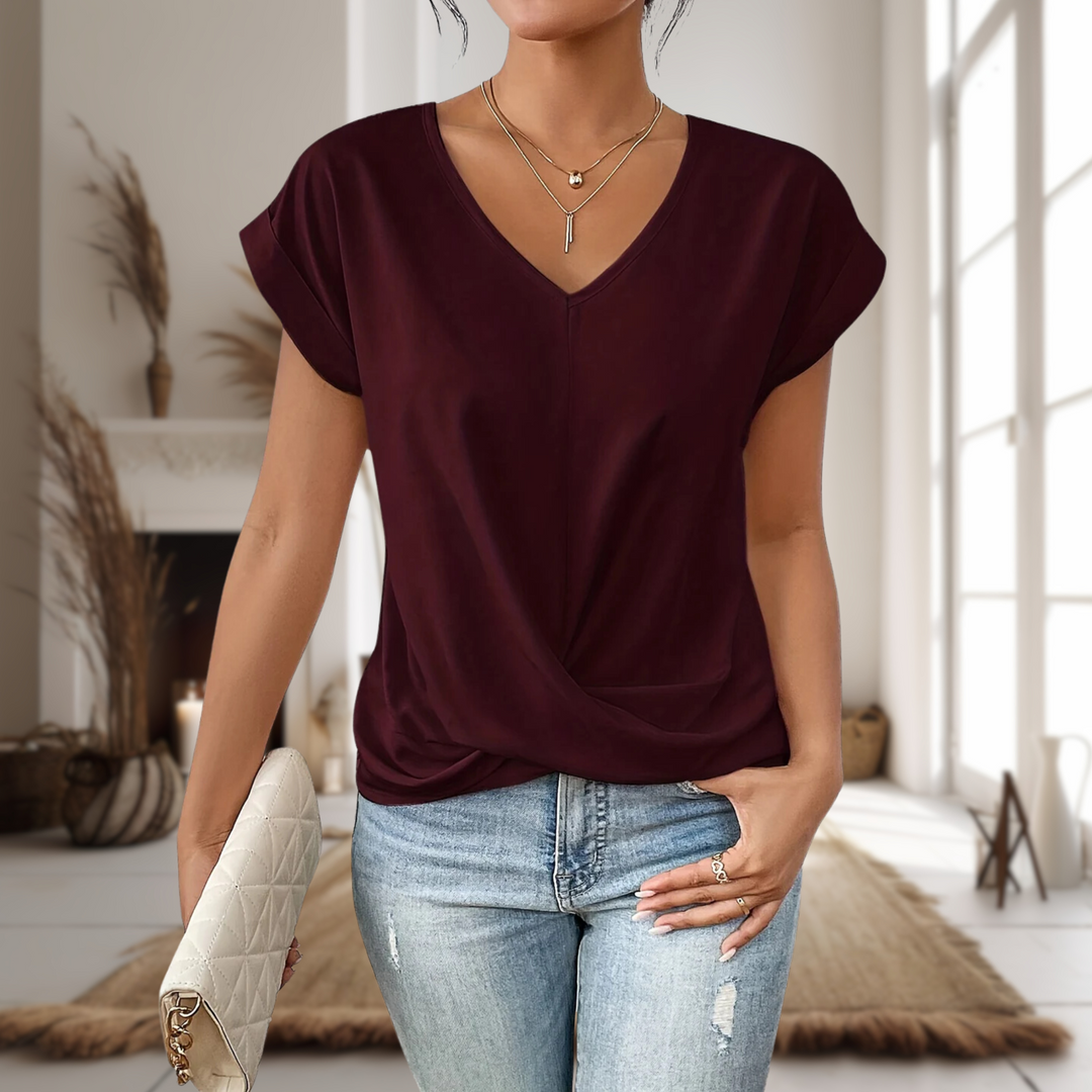 Woman wearing a sweetheart neck T-shirt against a plain background.