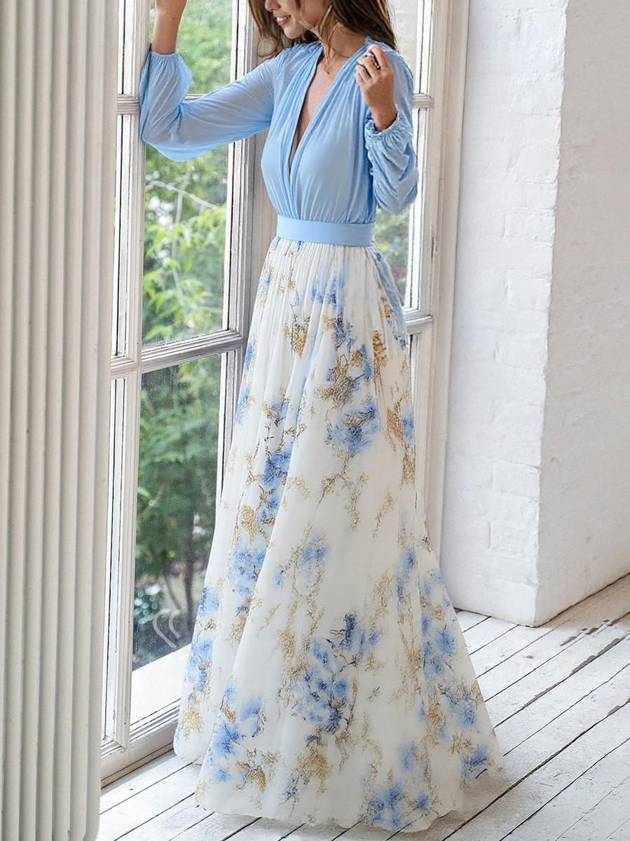 Female model in a floral long sleeve V-neck maxi dress against a plain background.
