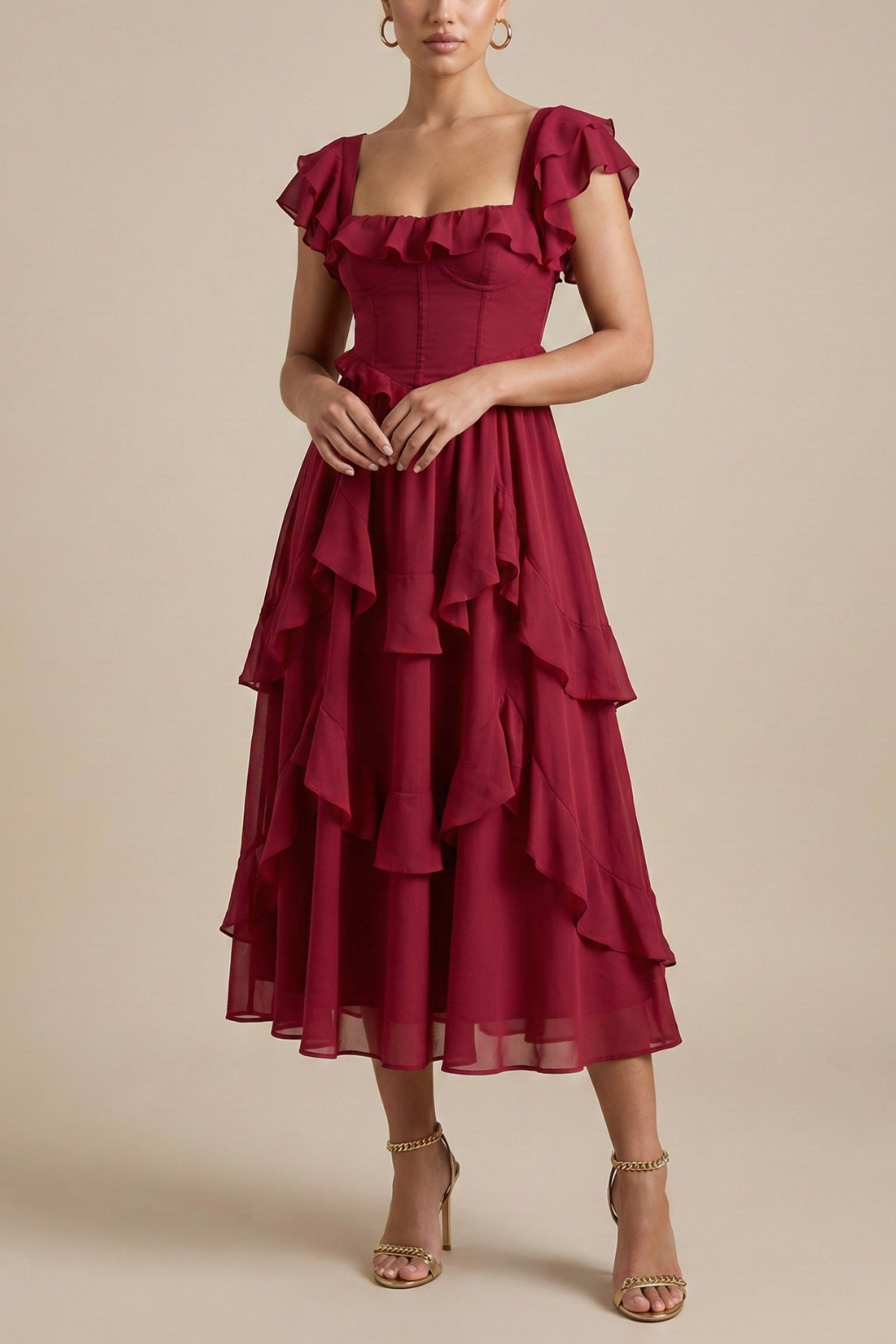 Female wearing a layered ruffle midi dress with flutter sleeves on a plain background.