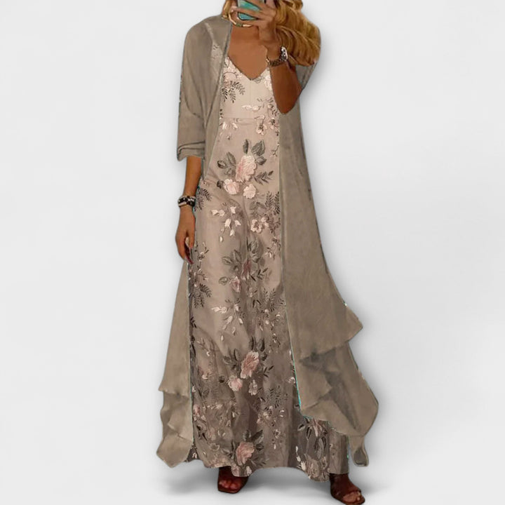 Female model wearing a floral maxi dress with a matching longline jacket against a plain background.