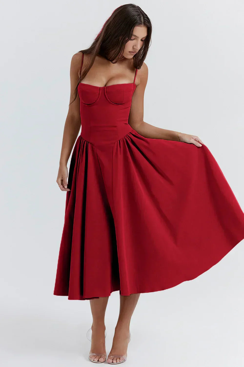 Woman in a graceful midi dress with a gathered waist on a plain background.