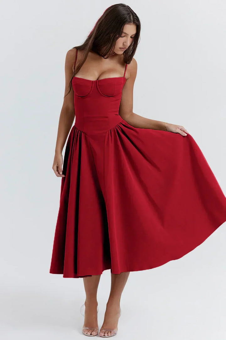 Woman in a graceful midi dress with a gathered waist on a plain background.