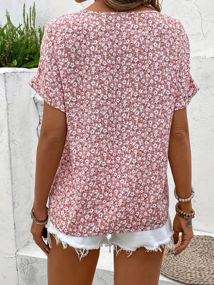  Woman showcasing a lightweight floral blouse with a relaxed fit on a plain background.