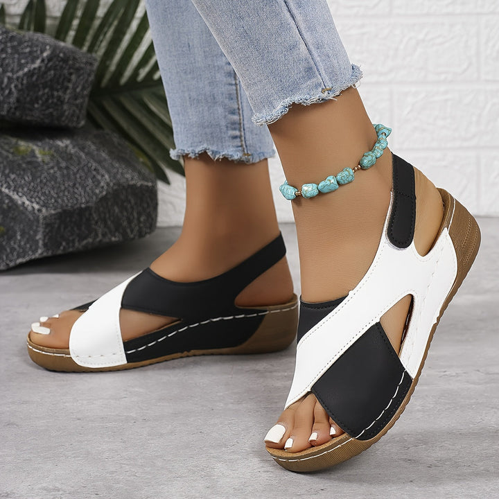 Woman wearing adjustable strap sandals on a plain background.