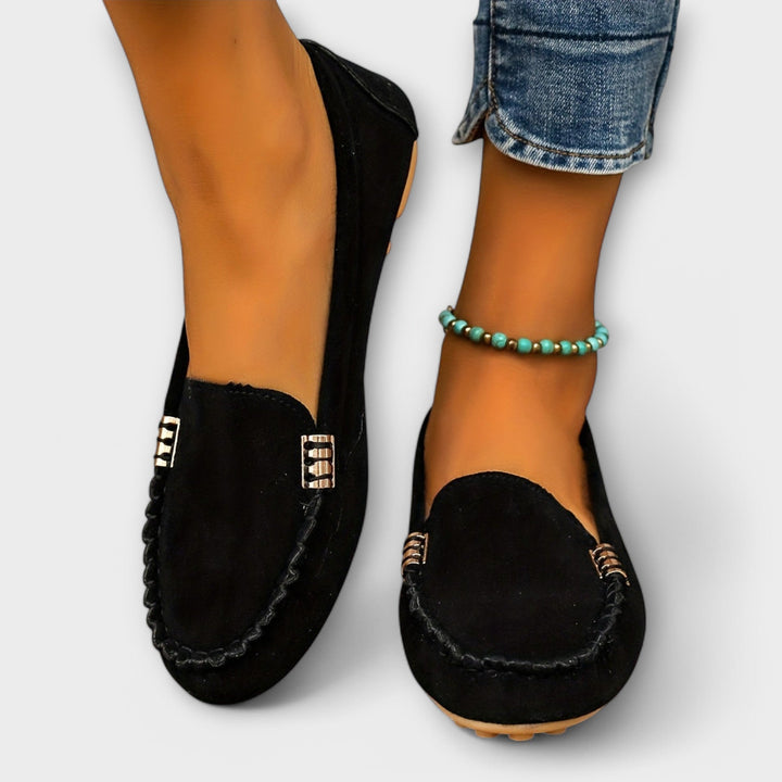 Woman standing in casual moccasin shoes with a simple everyday look.