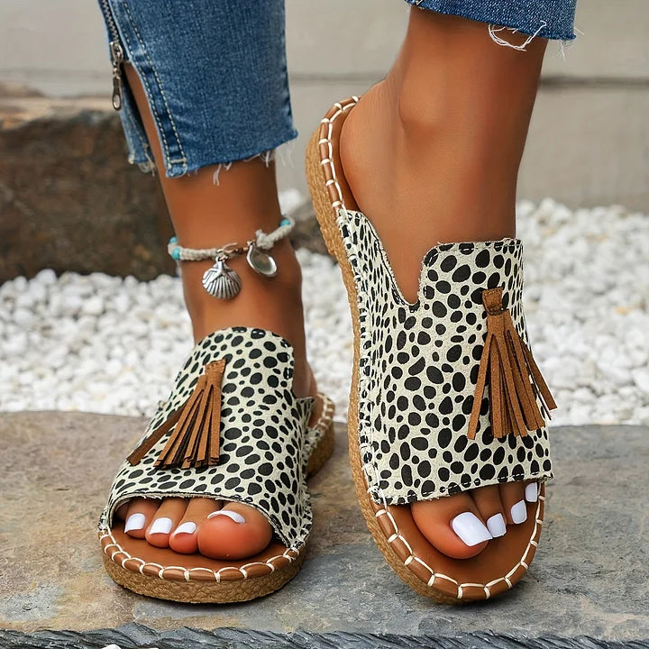 Female model showing casual sandals with bright tones on a plain background.