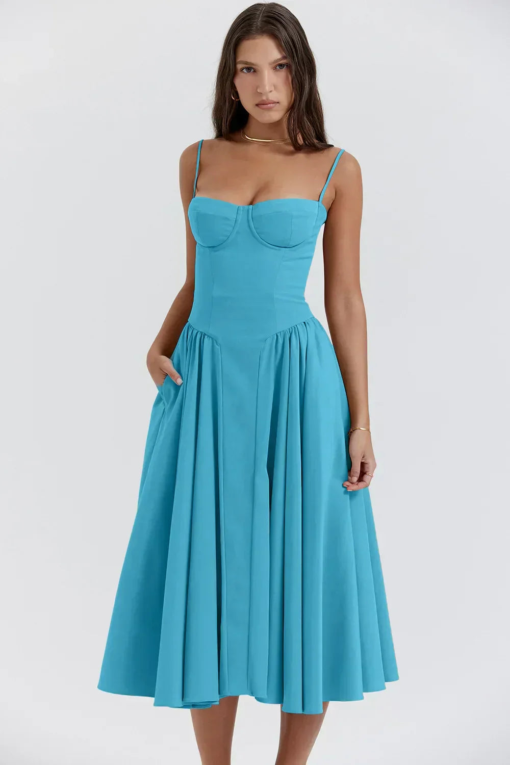 Female model in a warm-weather midi dress with gentle drape on a plain background.