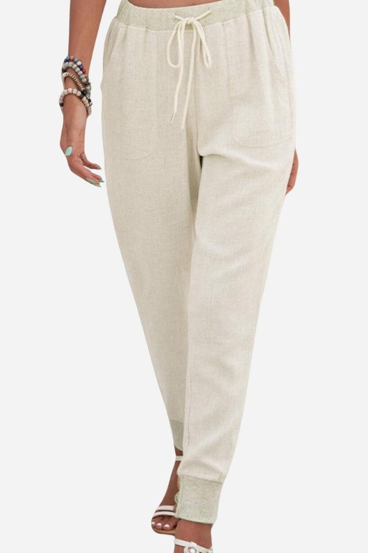Model wearing casual tapered ankle pants with an adjustable drawstring waist against a plain background.