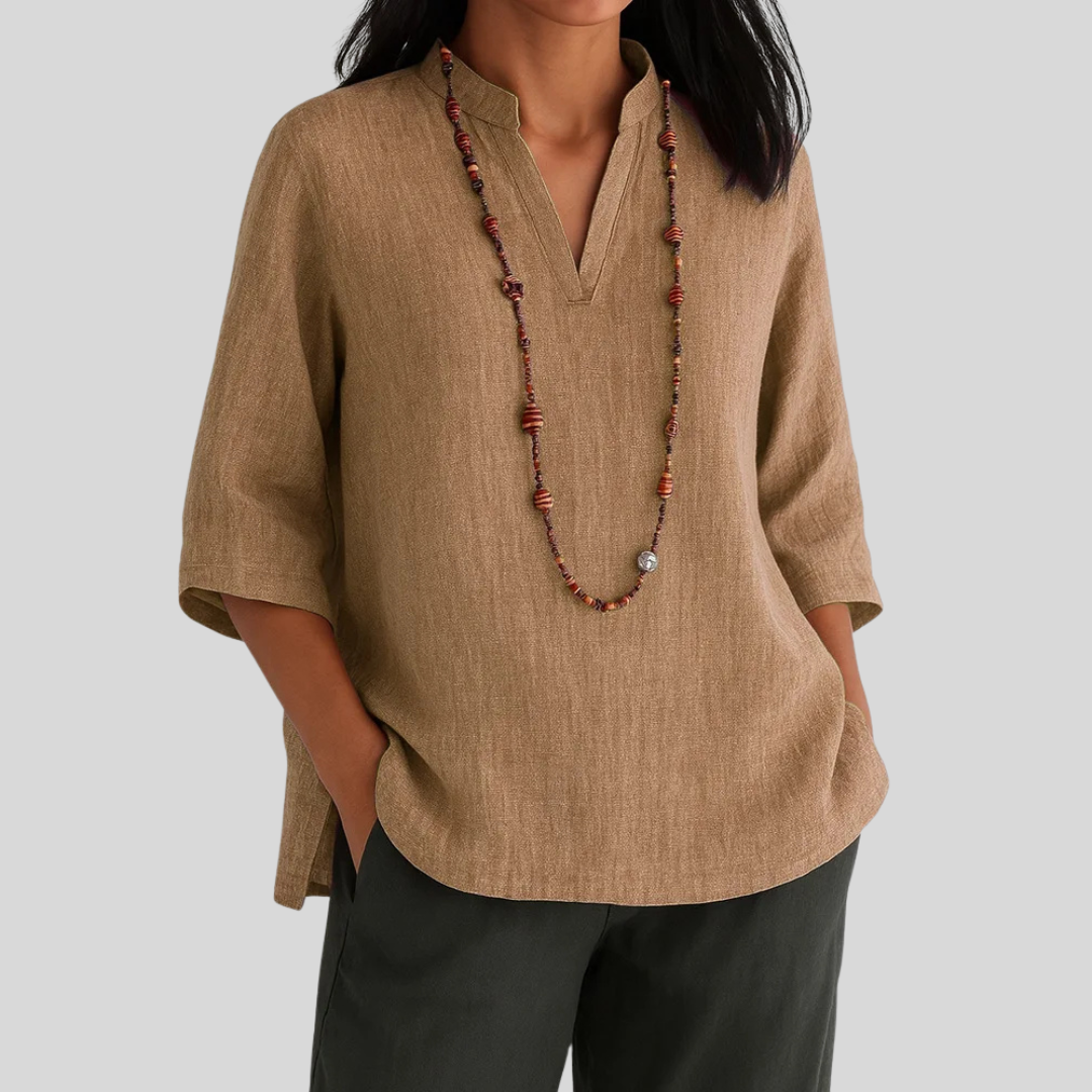  Female in a casual green blouse with a relaxed silhouette on a plain background.