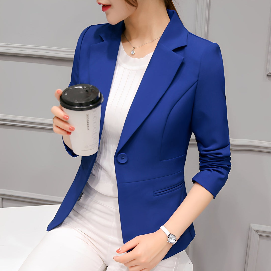 Woman showcasing an elegant fitted blazer with a single-button front closure on a plain background.