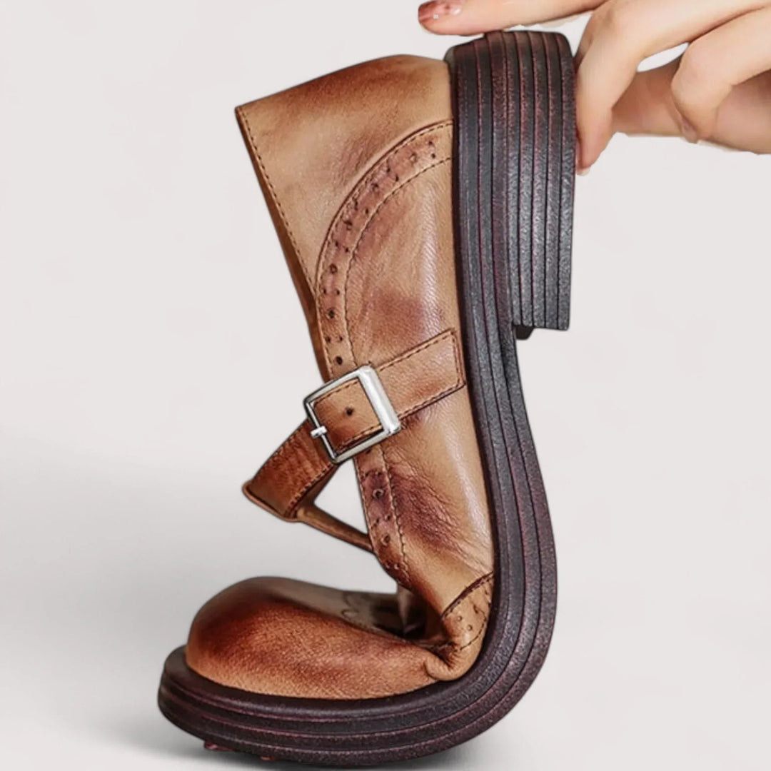 Flexible closed toe strap shoes on a plain background.