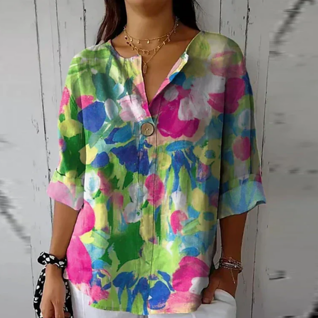  Female modelling a feminine printed blouse against a plain background.