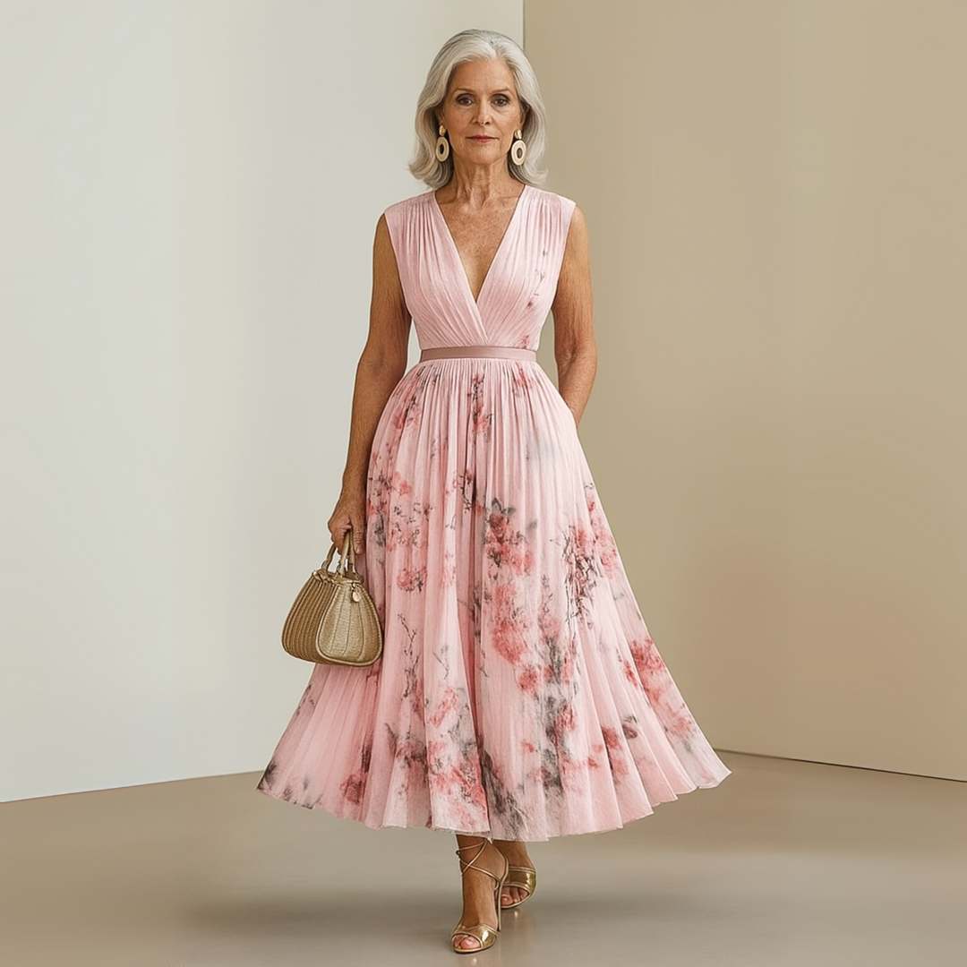Woman in a printed maxi dress with a sleeveless cut and pleated design.
